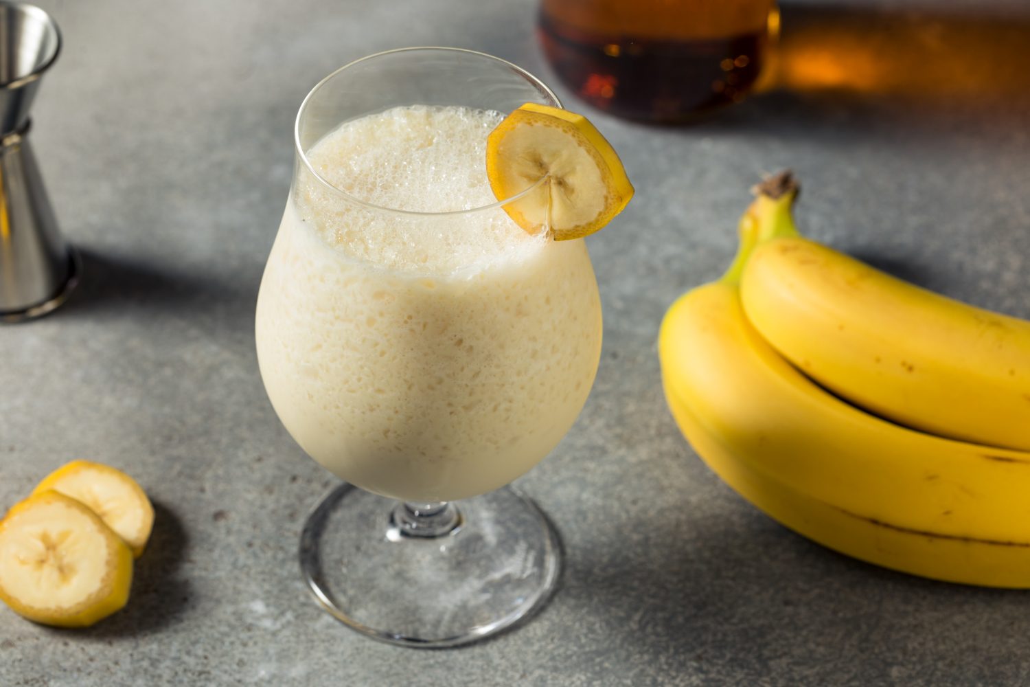 Banana Daiquiri - Ein cremiger Genuss im Sommer 1 Banana daiquiri auf steinplatte mit bananen
